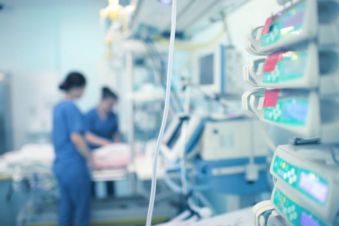 Medical professionals working while surrounded by medical instruments.